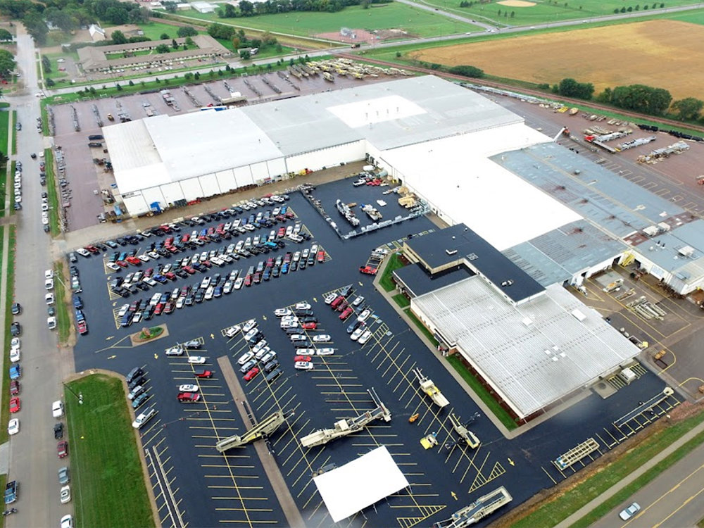Aerial view of Kolberg-Pioneer Inc. facility in Yankton, SD, showcasing the result of large-scale roof coating application for enhanced durability and waterproofing, with multiple bright white roofs