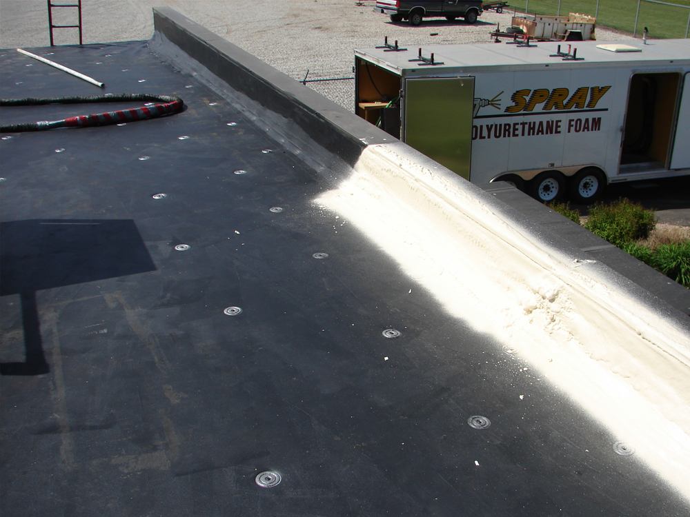 View from the top of the roof during the spray foam roofing application at Window World, Norfolk, NE, showcasing the EPDM rubber roof and NENES, Inc. Roofing trailer in the background