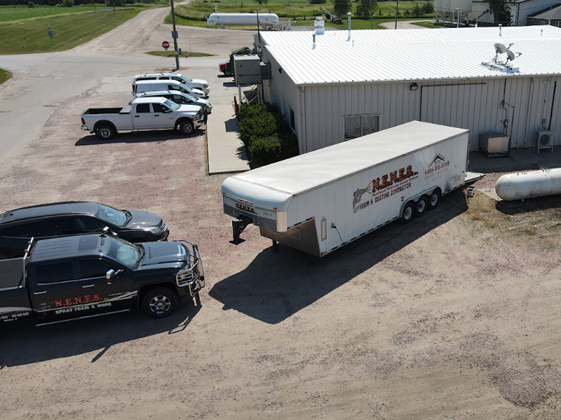 NENES, Inc. Roofing truck and trailer parked behind Main Express, LLC in Howells, NE